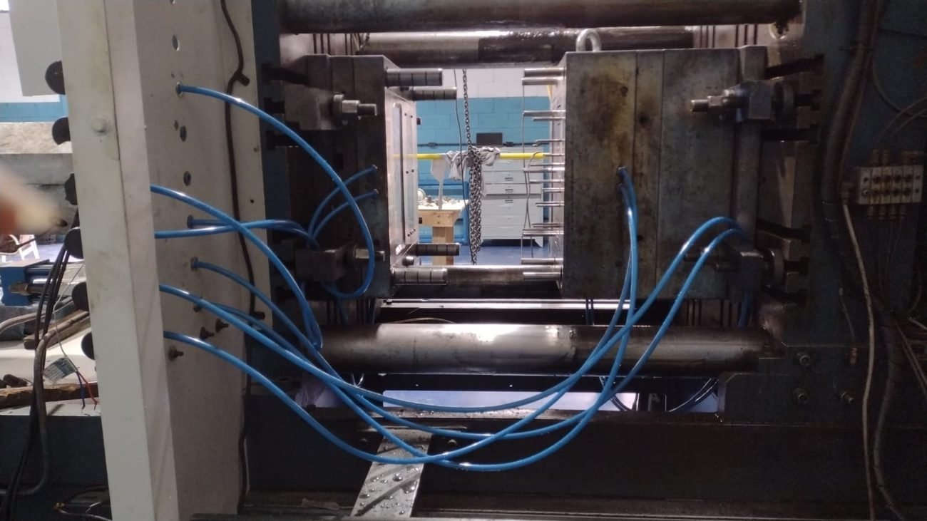 Molde aberto na injetora com linhas de refrigeração